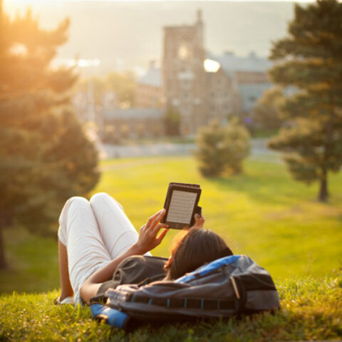 A student reads on Libe Slope in summer.