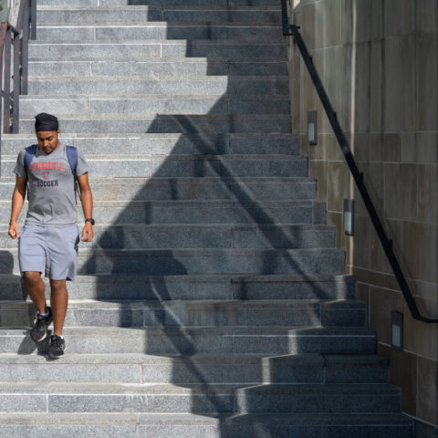 A student descends the stairs outside the Physical Science Building.