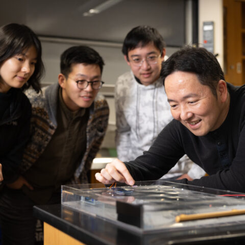 Sunny Jung, professor of biological and environmental engineering (far right) and study coauthors (from left), Jisoo Yuk, Chris Roh and Yicong Fu, watch a demonstration of their snail-inspired robot.