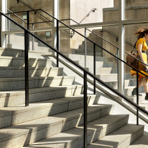 A student descends the steps outside the Physical Science Building.