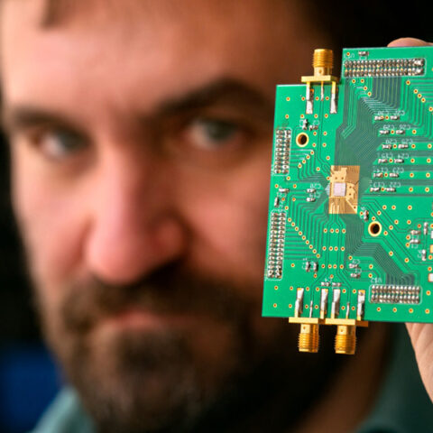 Alyosha Molnar, associate professor of electrical and computer engineering (ECE), with a mobile phone chip he developed.