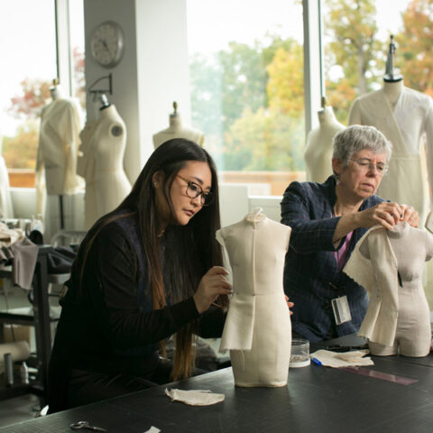 Susan Ashdown, professor of Fiber Science and Apparel Design (FSAD), works with a graduate student on halfscale dress forms in the FSAD studio.